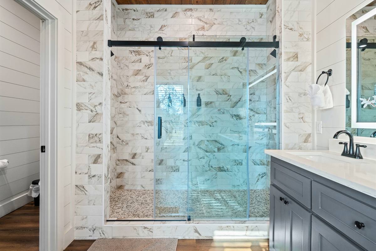 Light, bright, and stylish, this bathroom space feels fresh and comfortable with beautiful tile and updated fixtures.