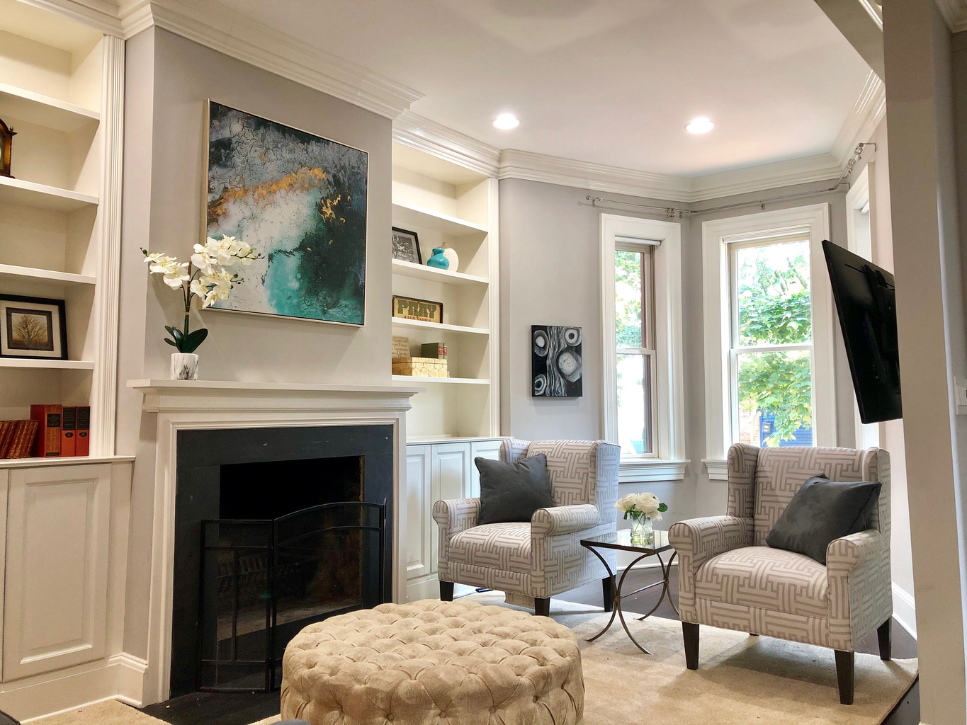 Step inside this elegantly styled living room with custom built-ins, cozy accents, and beautiful natural light to welcome you.