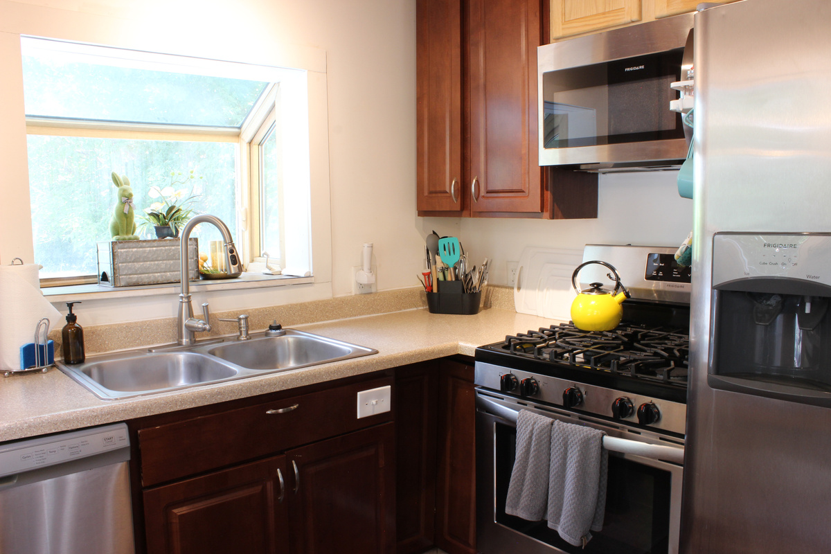 Stainless steel appliances and lots of cleaning supplies can be found beneath the sink.