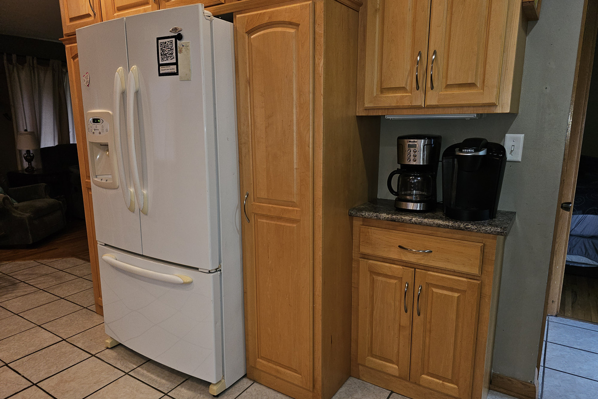 Two different types of coffee makers, full refrigerator