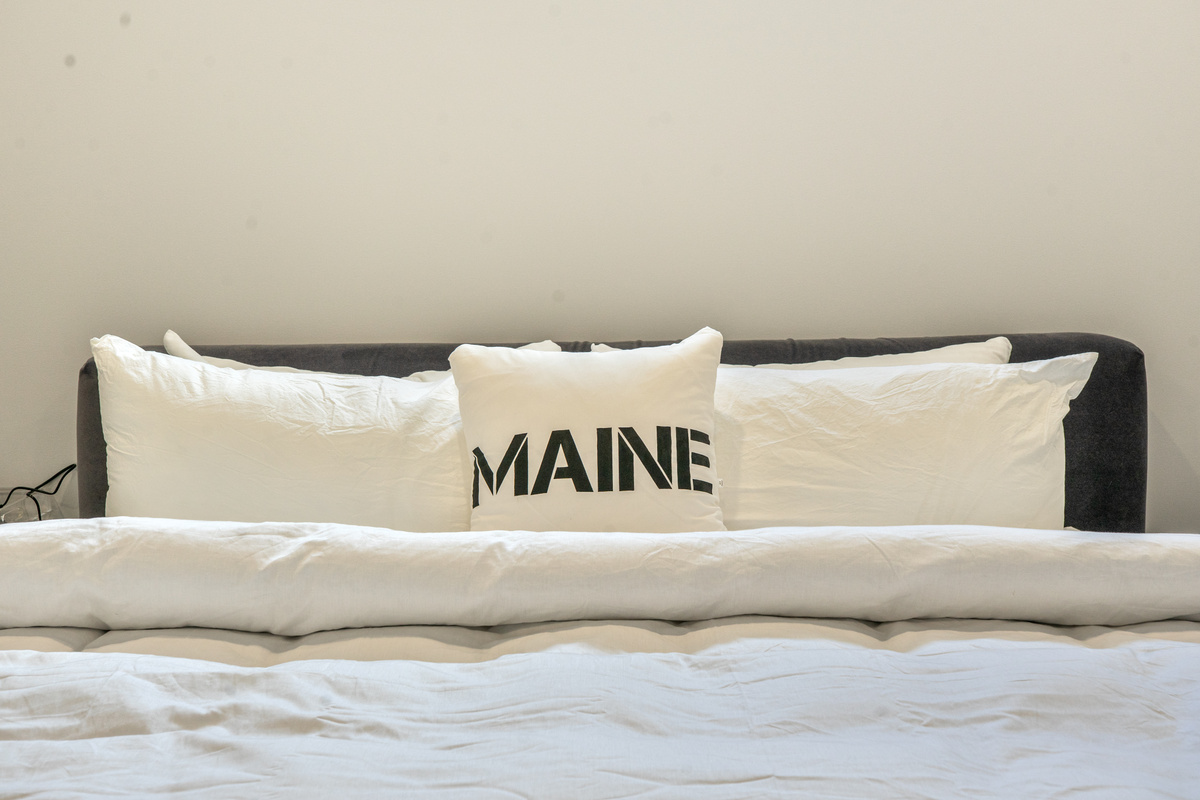 A thoughtful coastal touch in the primary suite. Unwind on the King bed, framed by a dark gray headboard and plush white linens. Enjoy clean residential comfort and modern design right in the heart of downtown Bar Harbor.