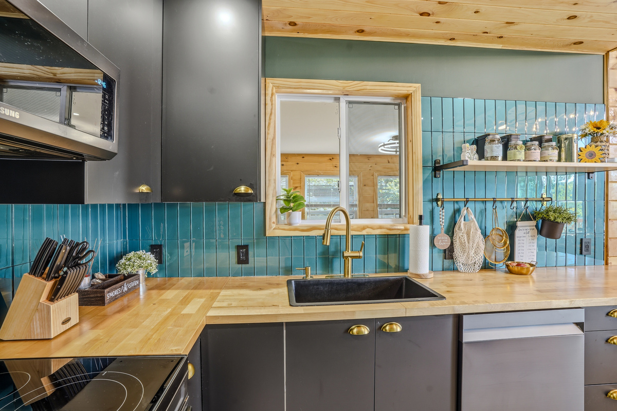 Kitchen counter view with open shelving, sink, and full appliance suite