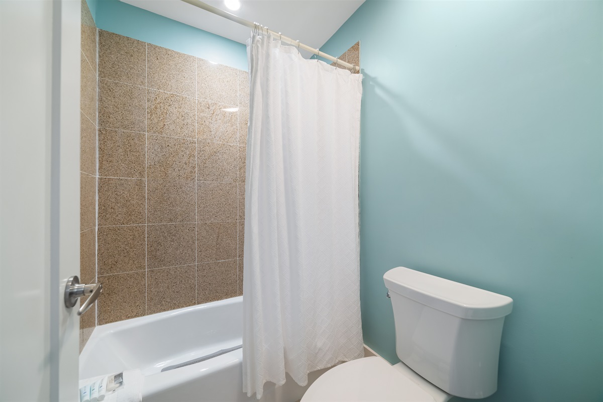 Freshly updated bathroom featuring a shower/tub combination, ample vanity space, and modern fixtures.
