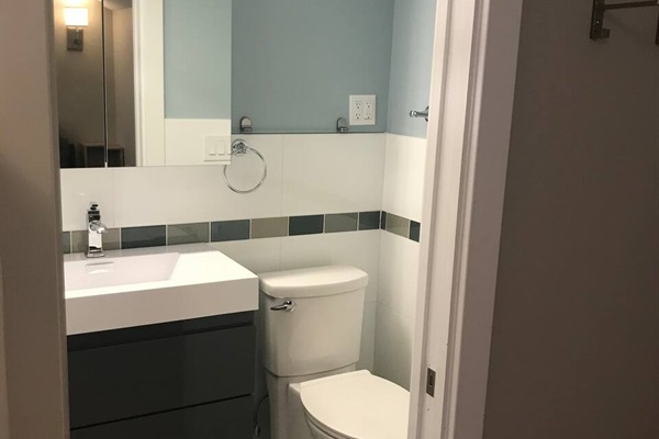 All tiled walled, large medicine cabinet, drawer storage in large sink vanity, towel holders, glass shelf, clothing hooks, lots of outlets and lighting. This bathroom is easy to be in.