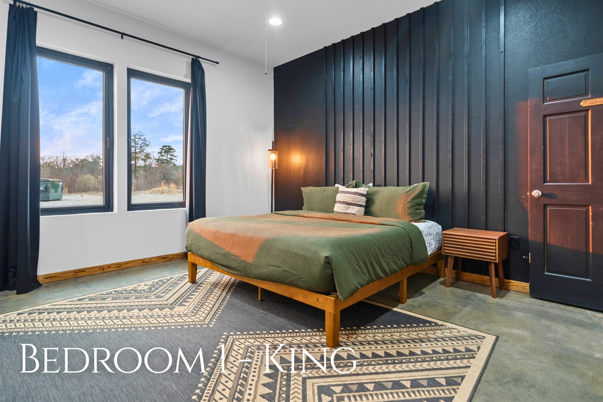 Bedroom 1 features a comfortable king bed, stylish accents, and large windows that let in beautiful natural light.