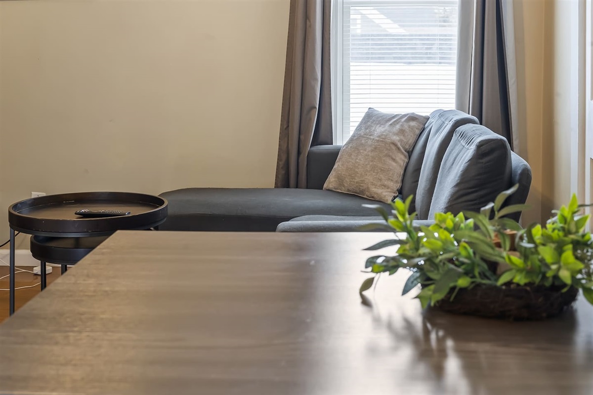 View of the cozy living room couch from the dining area, creating an open and inviting space for relaxation and meals.