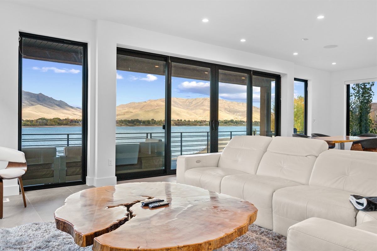 Bright main living room with panoramic lake and mountain views.