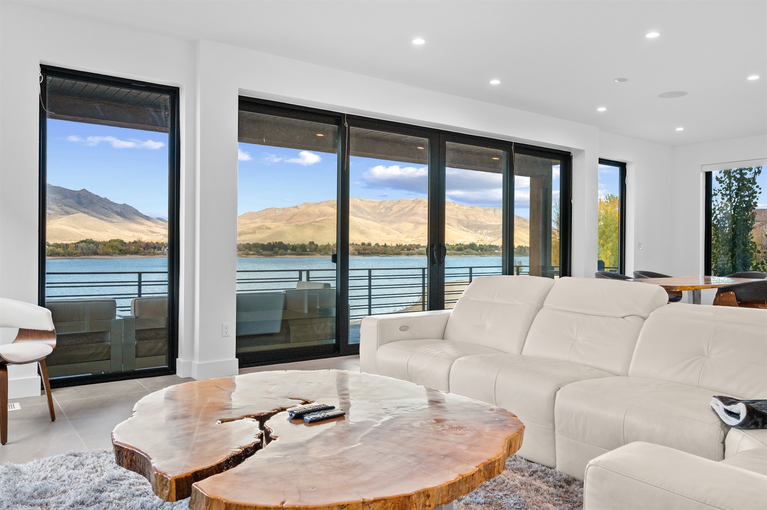 Bright main living room with panoramic lake and mountain views.