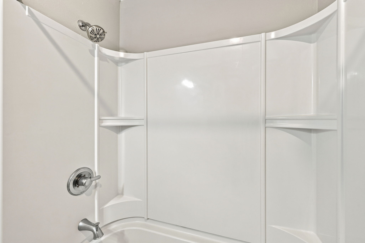 A bright bathroom space with a relaxing shower and tub setup, perfect for refreshing after a day at the beach