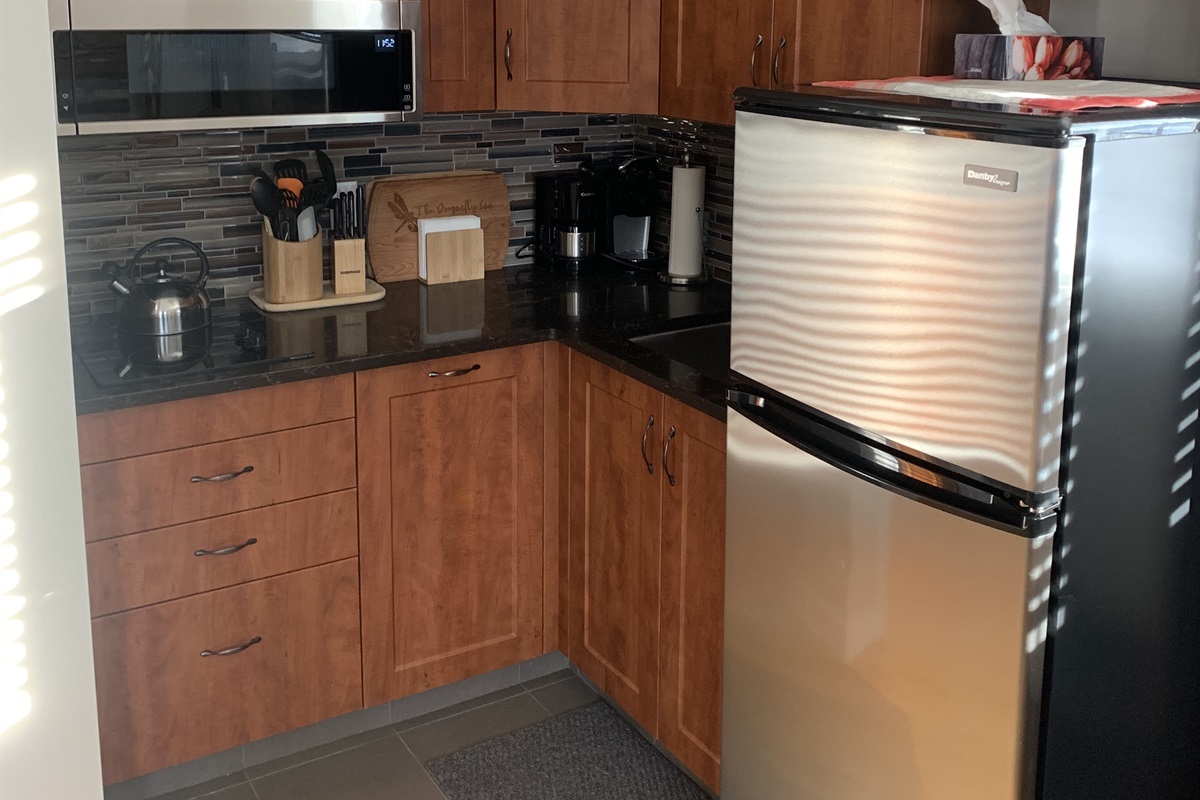 LOFT KITCHEN. TWO BURNER COOK TOP, CONVECTION MICROWAVE, FRIDGE FREEZER AS WELL AS ALL THE KITCHEN BASICS. POTS, PANS, DISHES, CONDIMENTS, SPICES AND COFFEE SUPPLIES.