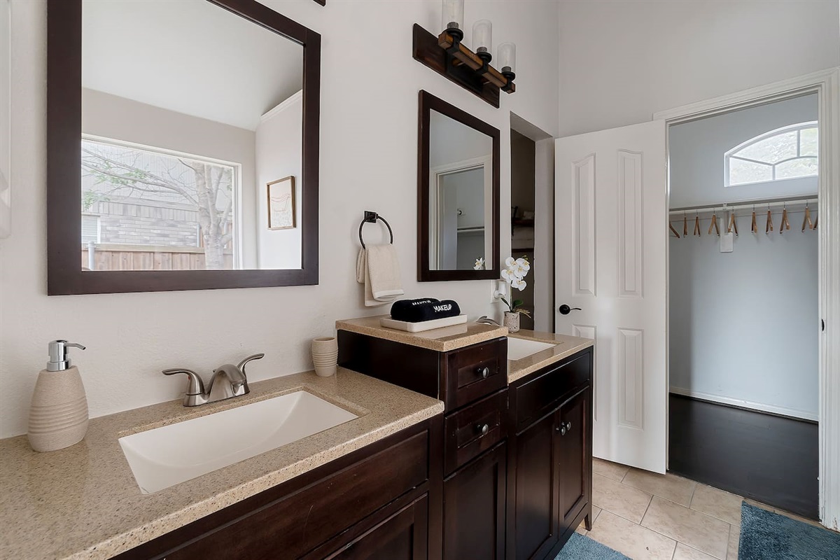 Step into this luxurious bathroom featuring a sleek sink and mirror combo, an inviting bathtub. Pamper yourself in style and comfort.