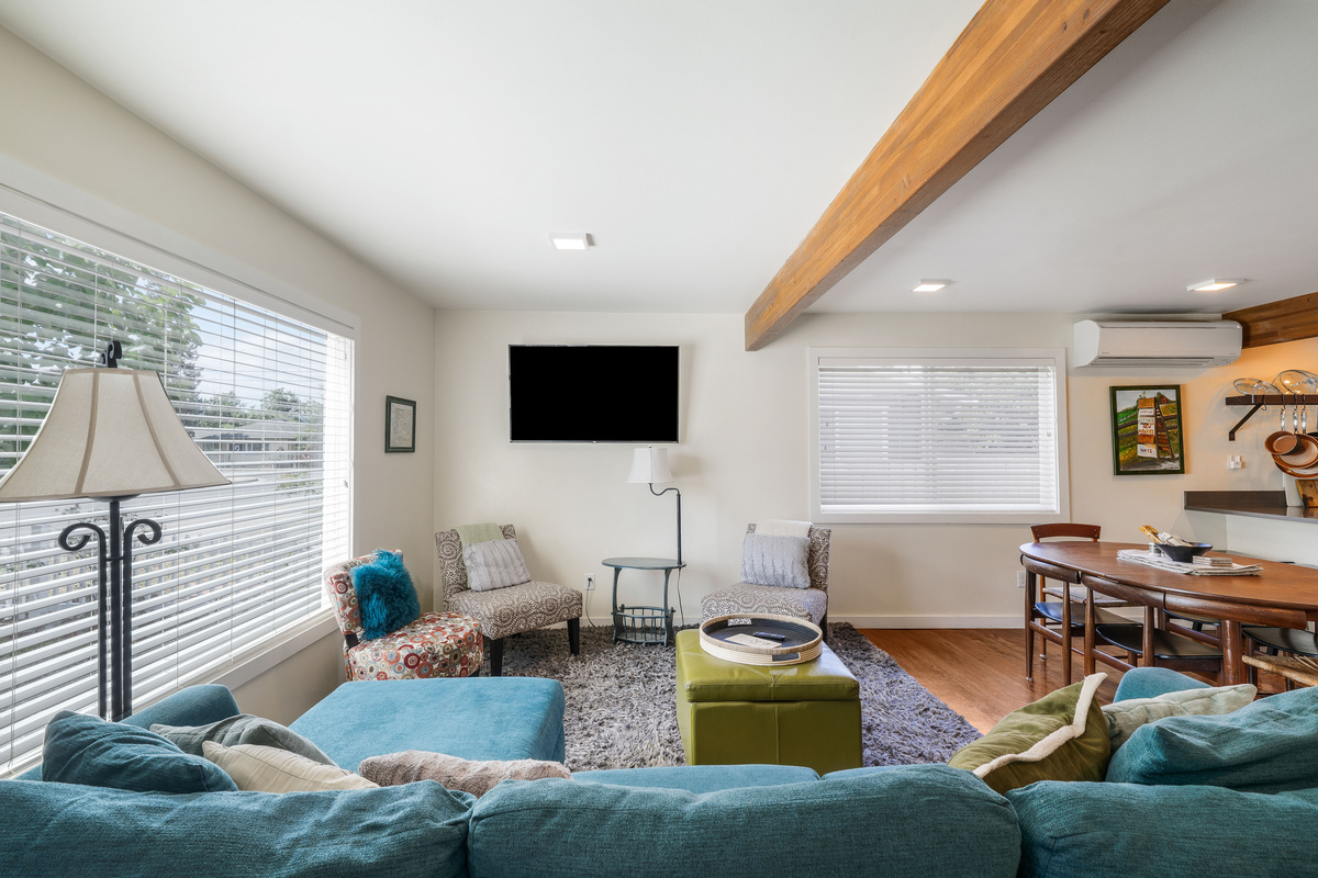 A large picture window in the living room overlooks a fenced front yard and the park across the street. 