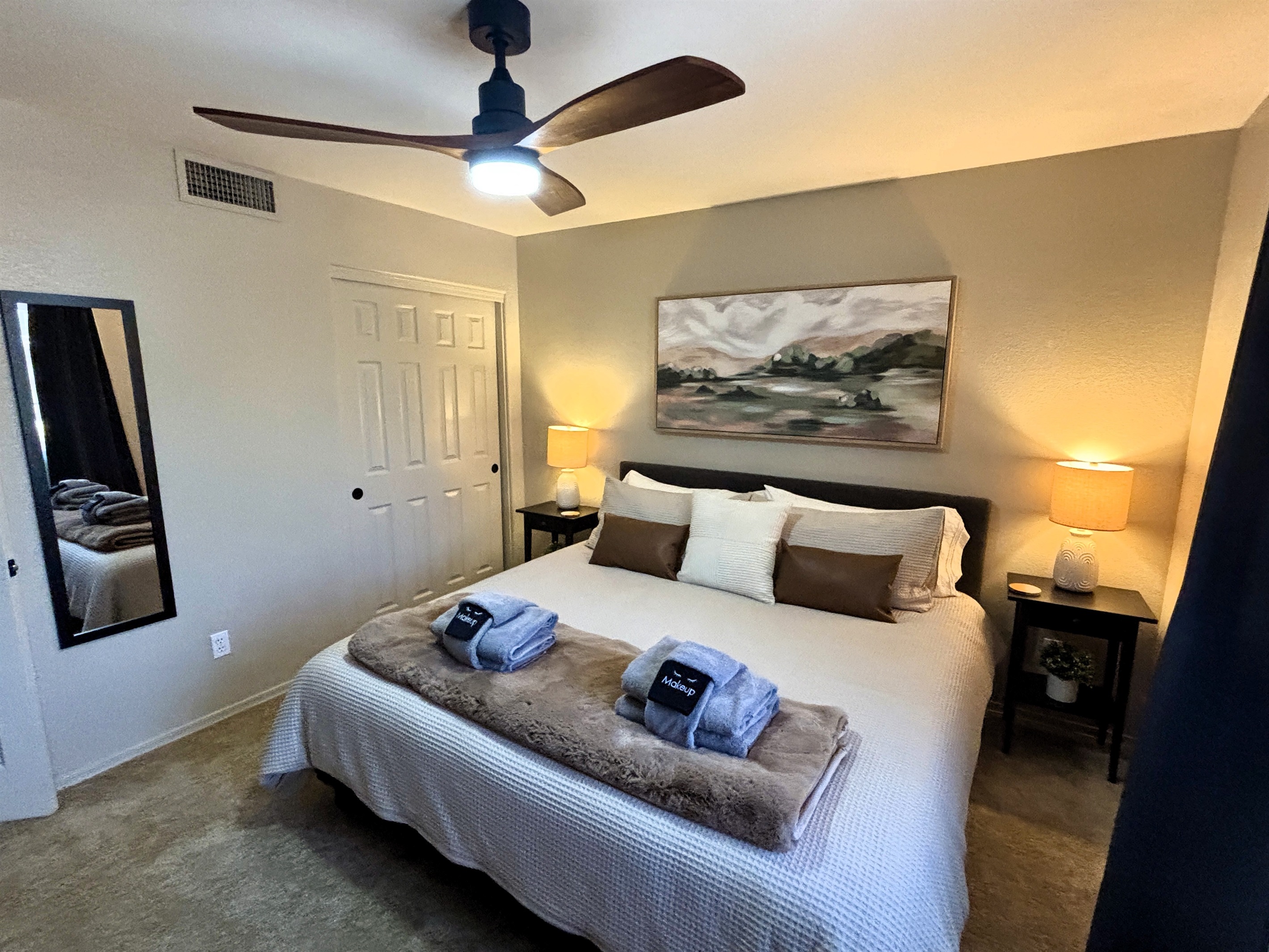 Bedroom with king bed, smart TV, ceiling fan, blackout curtains and linens