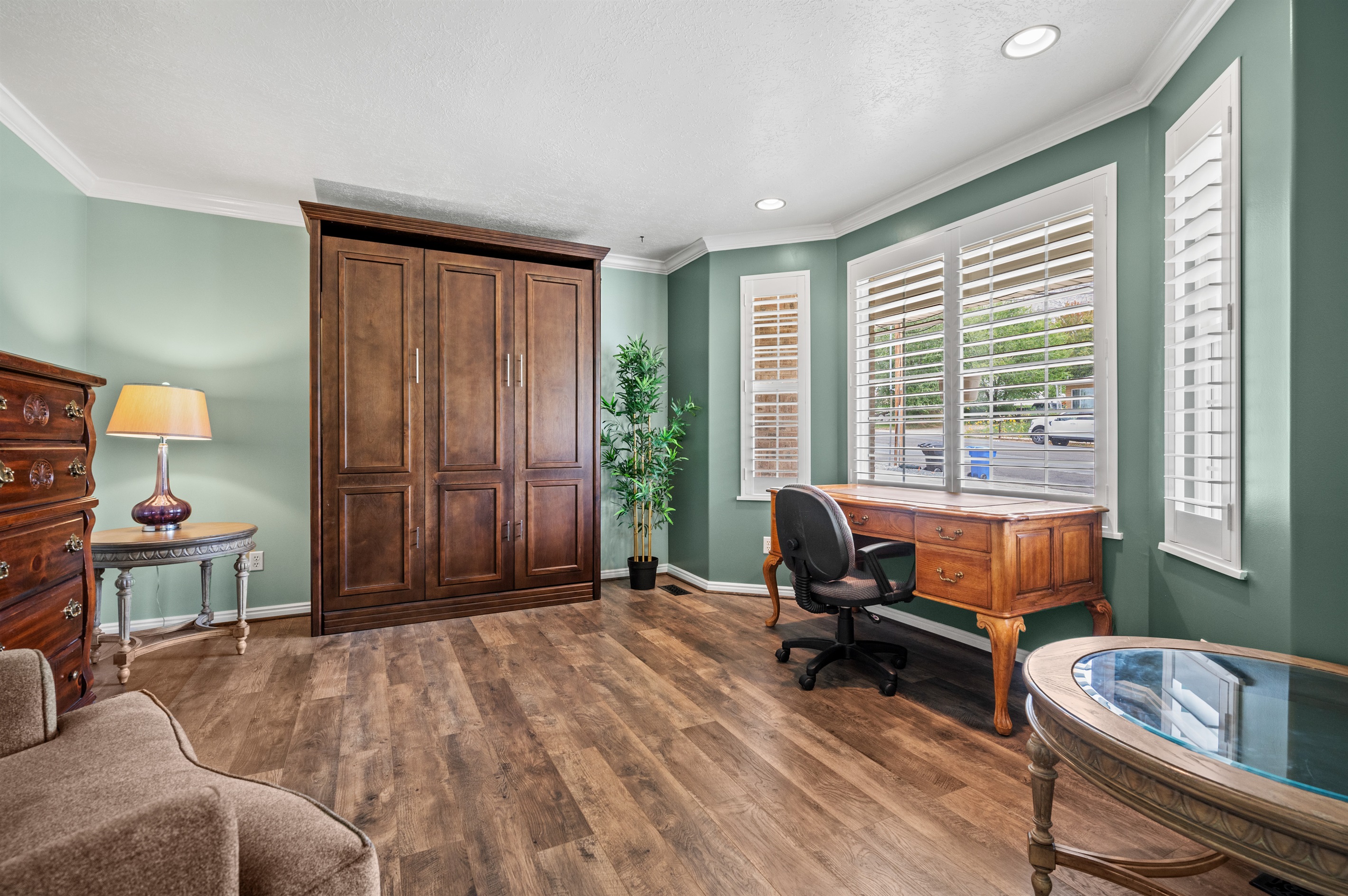 Bright office with large windows, desk, and seating area — an ideal setup for remote work or peaceful relaxation with natural light.