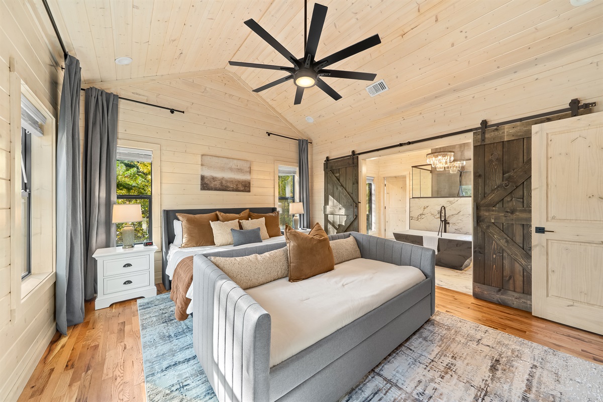 Peaceful king suite with an added daybed and sliding barn doors leading directly into a luxury ensuite bathroom.