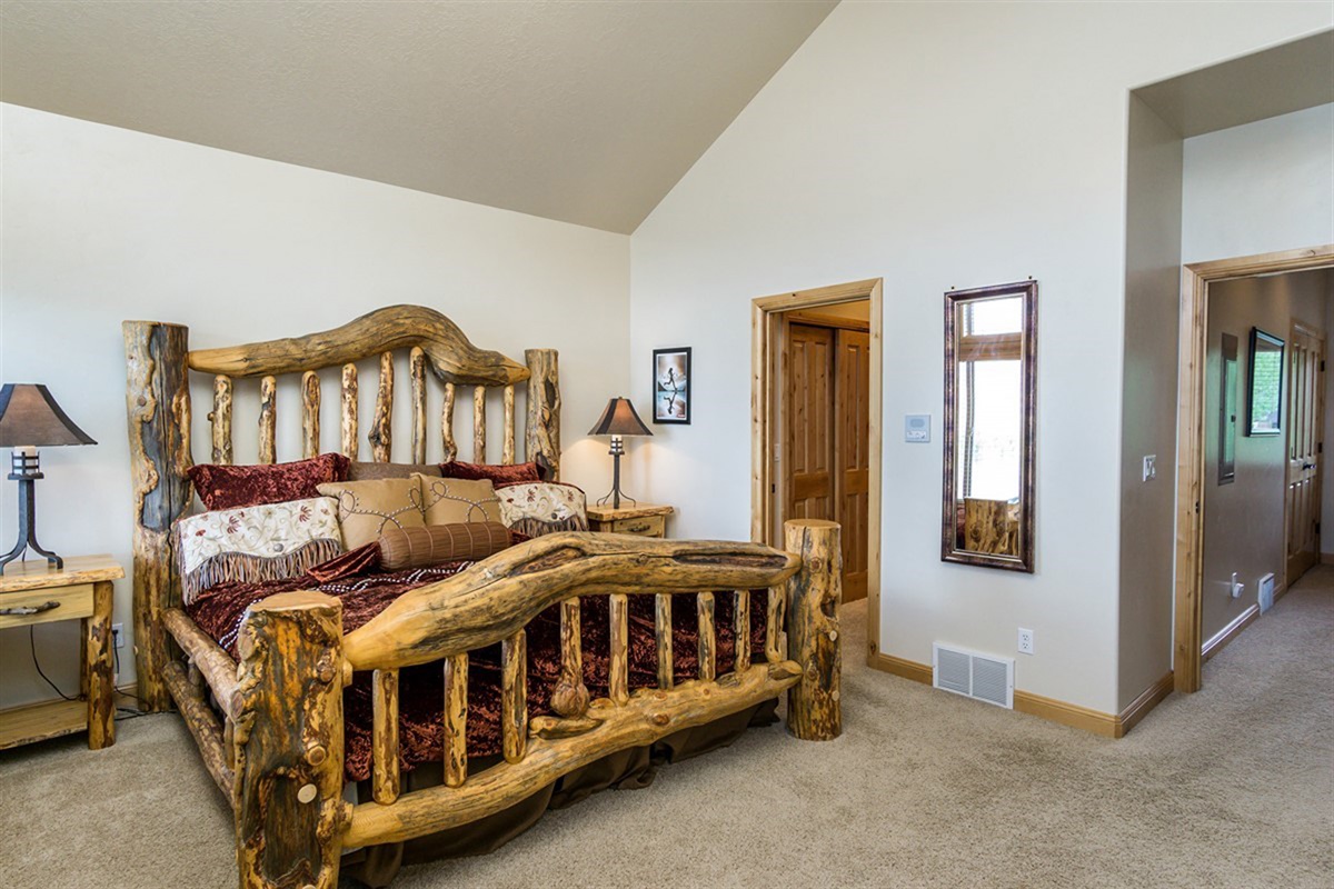 A spacious bedroom with rustic wood furnishings and thoughtful layout, blending comfort with timeless alpine style.
