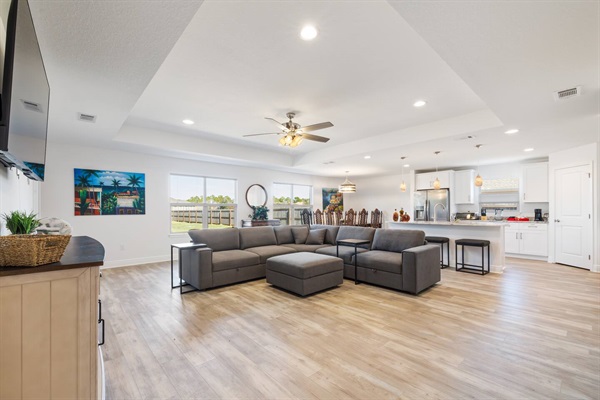 From the entrance hallway, a view of the living room, with the dining room in the back and kitchen to the right.