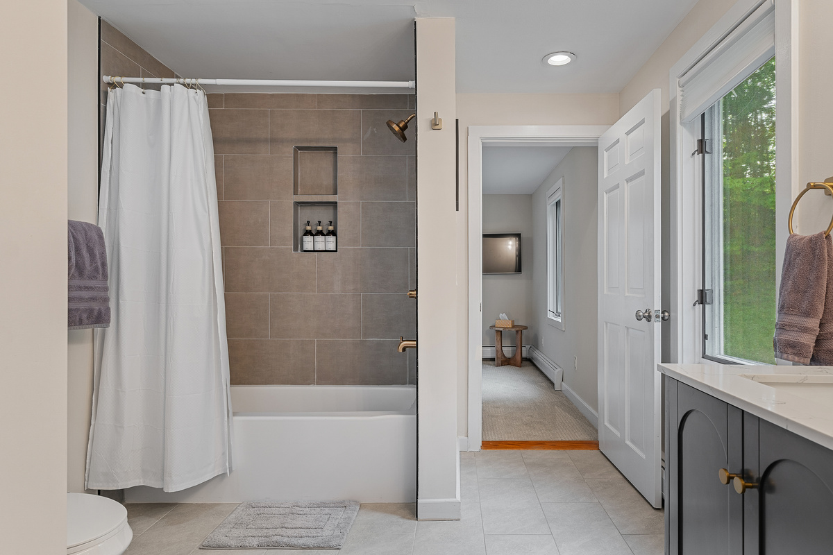 Full guest bathroom with tiled tub and shower combination