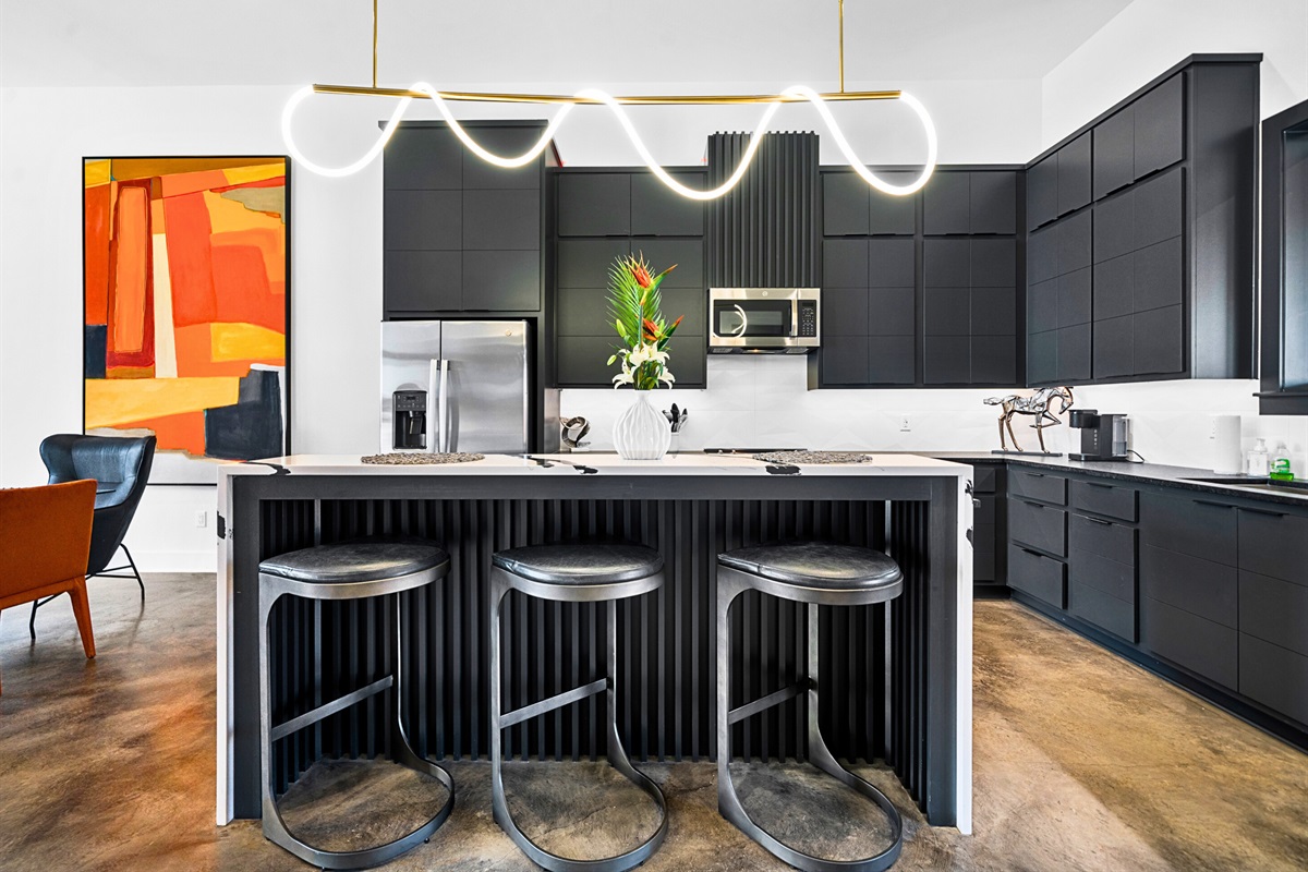 Striking gold pendant lights and clean, modern lines give this kitchen a luxurious edge, while the open layout makes it perfect for hosting or cooking up your favorite meals.