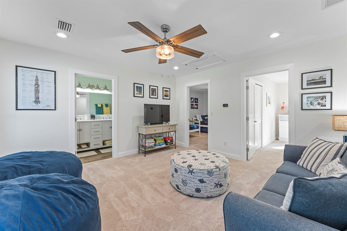 Upstairs family room area with TV, sofa and bean bag seating