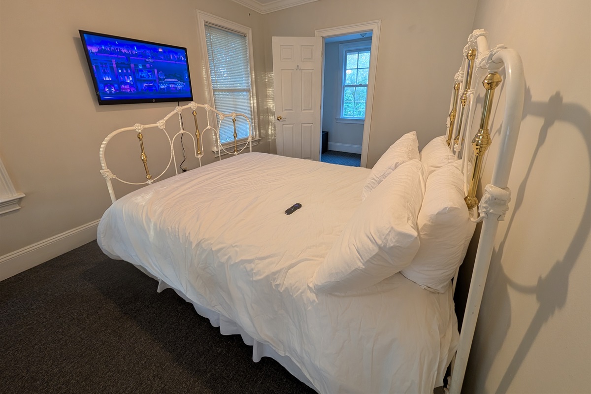 Upstairs guest bedroom with smart tv and queen bed