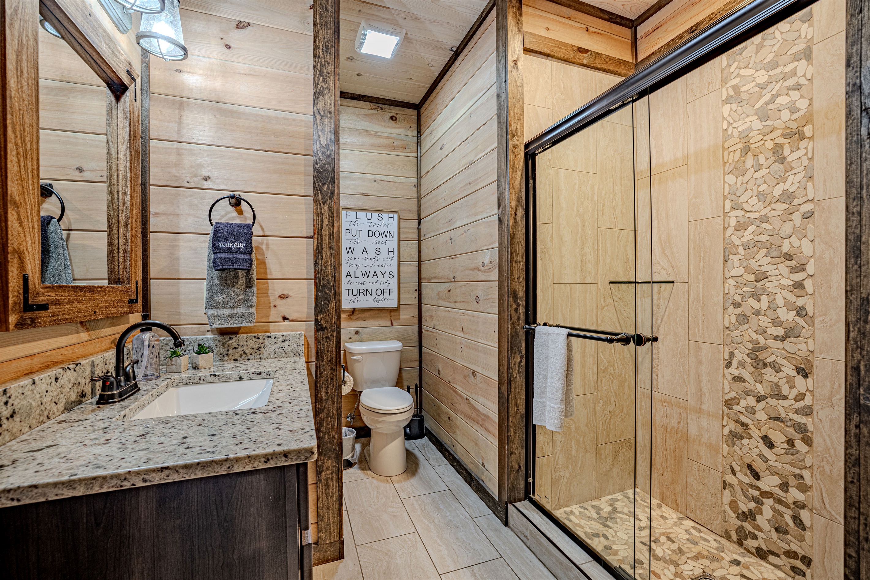 Modern full bathroom with walk-in tile shower and granite vanity.