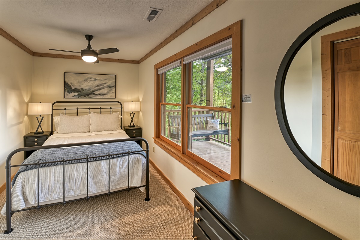 Basement level queen bedroom has a ceiling fan, dresser, closet and usb ports built into the touch lamps next to the bed.