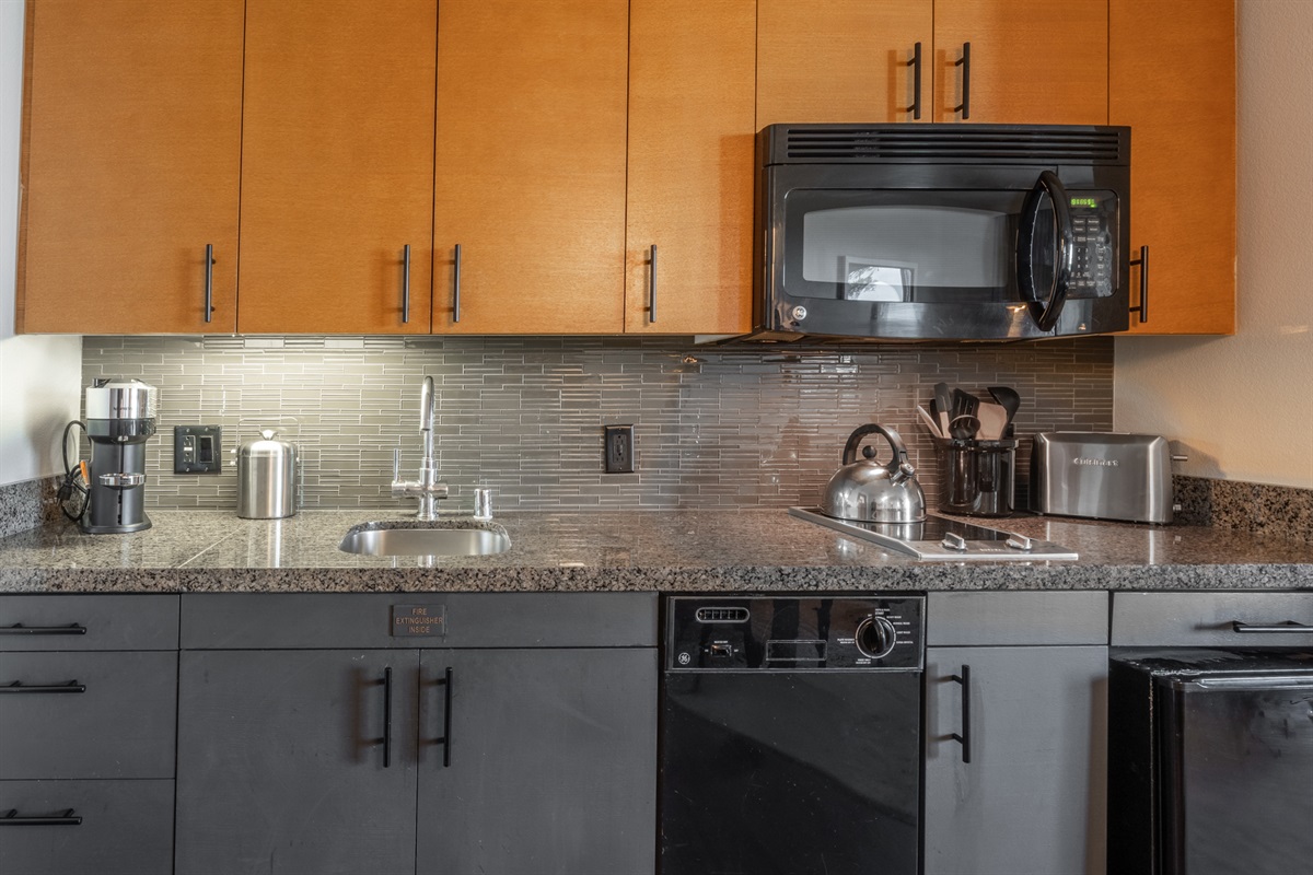 Designed for convenience, the kitchen includes a fridge, dishwasher, microwave, cooktop, and handy small appliances—perfect for everything from quick breakfasts to cozy dinners in.