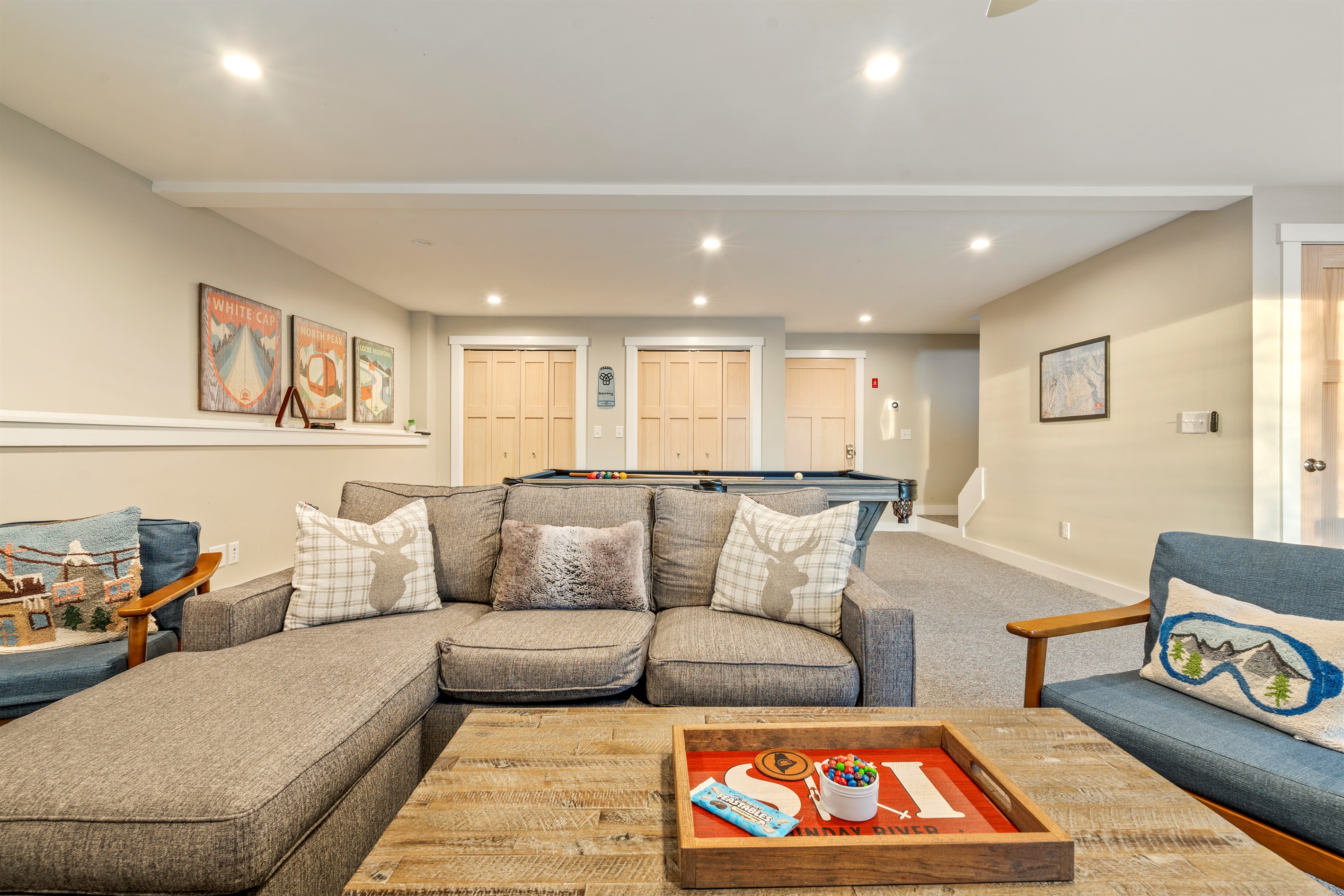 Basement game room featuring a cozy lounge and large TV for movie nights.
