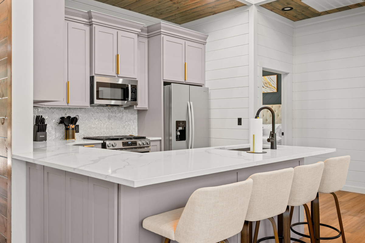 The kitchen features modern finishes, ample counter space, and seating that keeps everyone connected while meals are prepared.