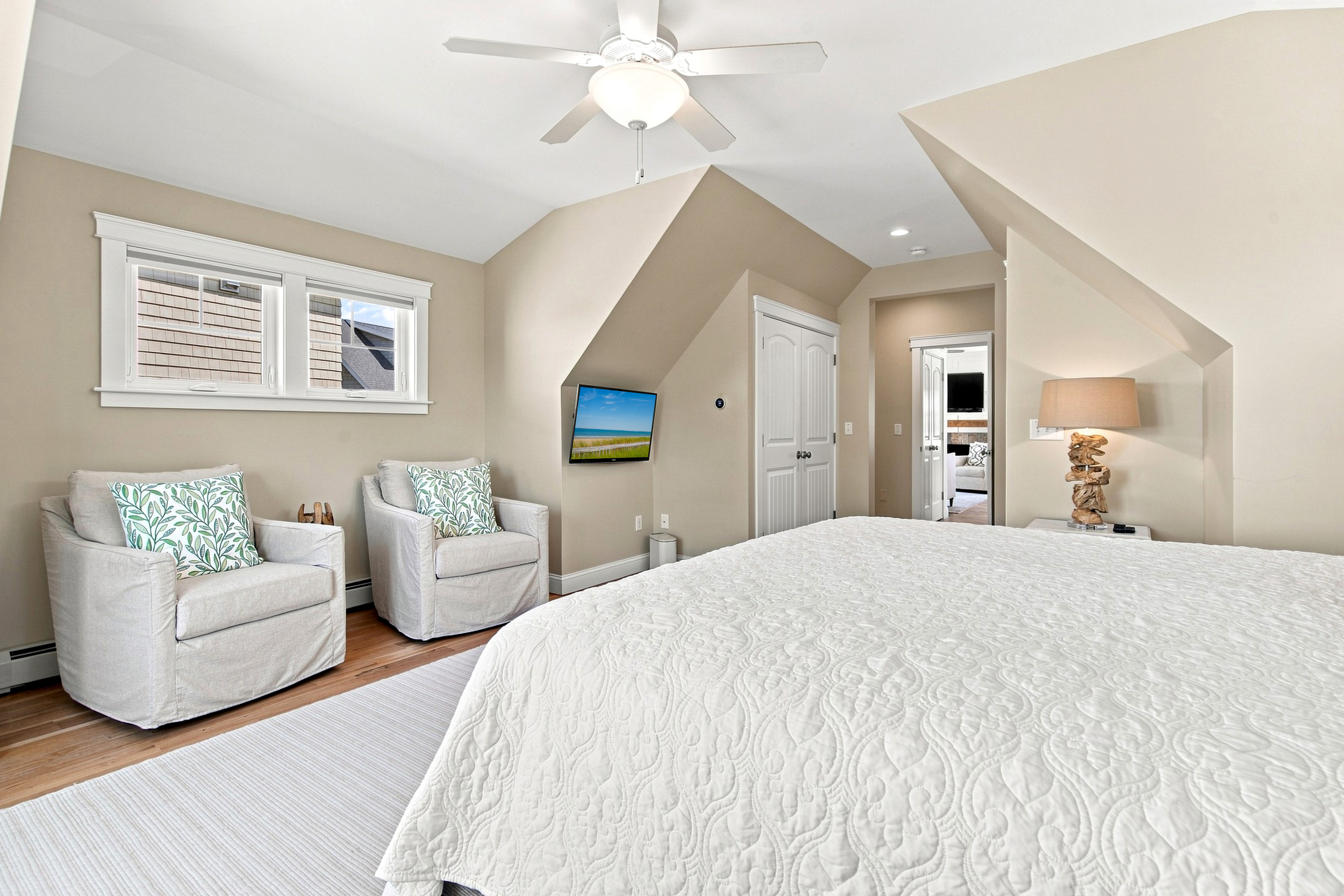 A restful bedroom retreat with soft coastal tones, comfortable seating, and a bright, airy atmosphere.