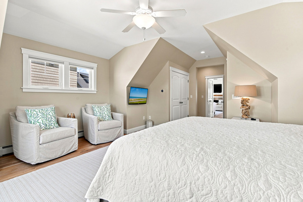 A restful bedroom retreat with soft coastal tones, comfortable seating, and a bright, airy atmosphere.