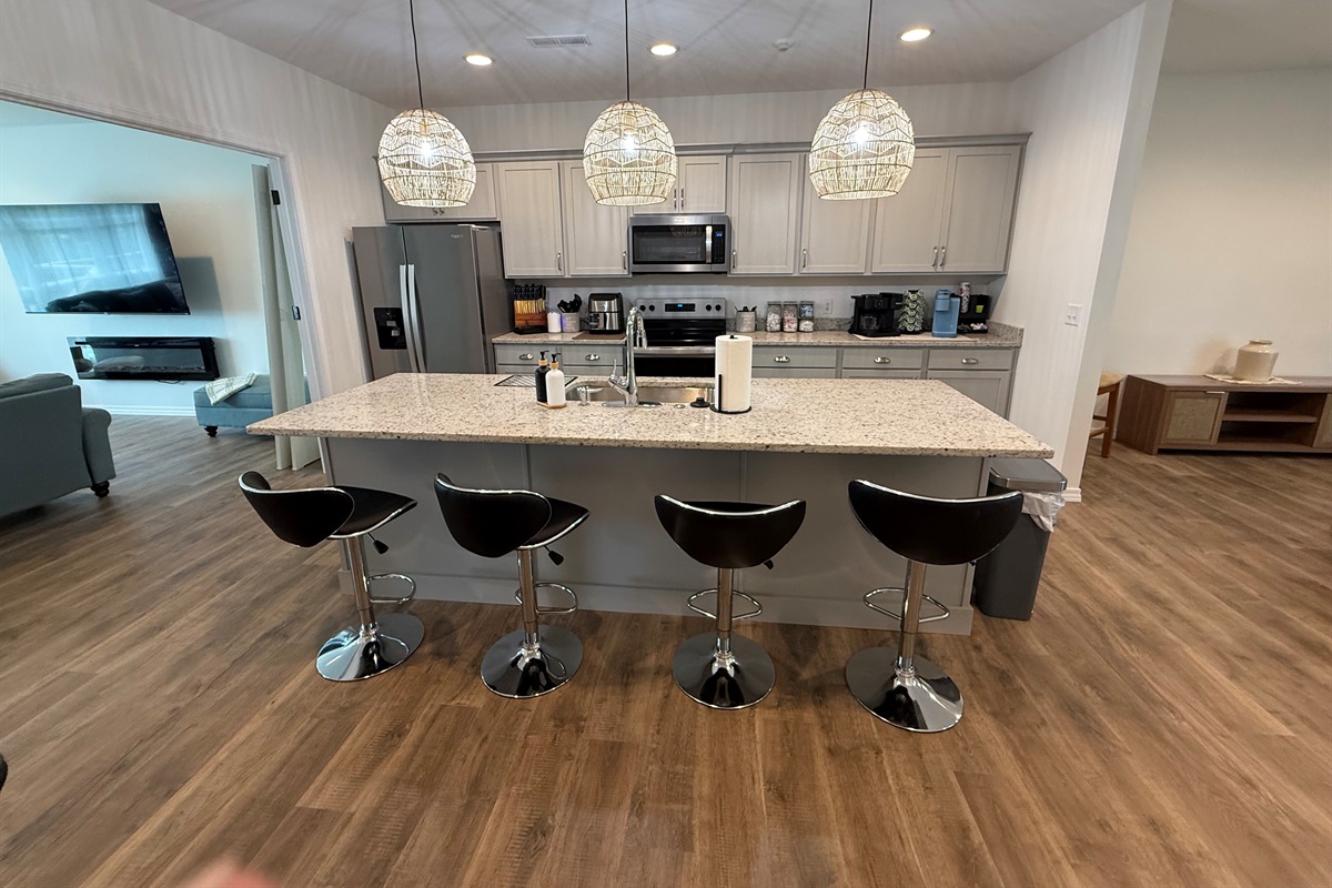 Open gourmet kitchen with stools at 6’ long island