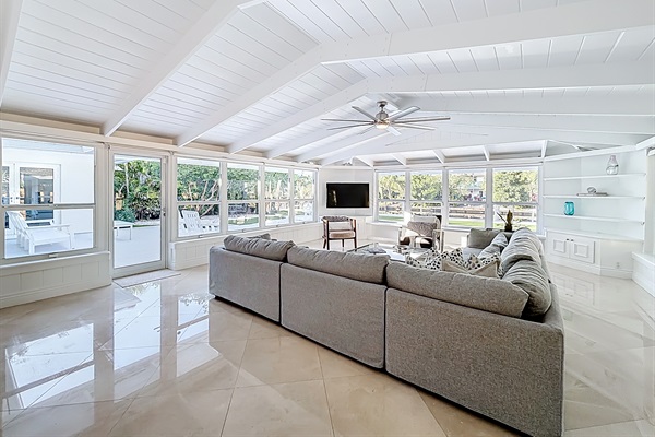 Livingroom with an amazing wraparound view- Pool, water, a true tropical setting. Sit on the wrap around bench and feel practically outside. 