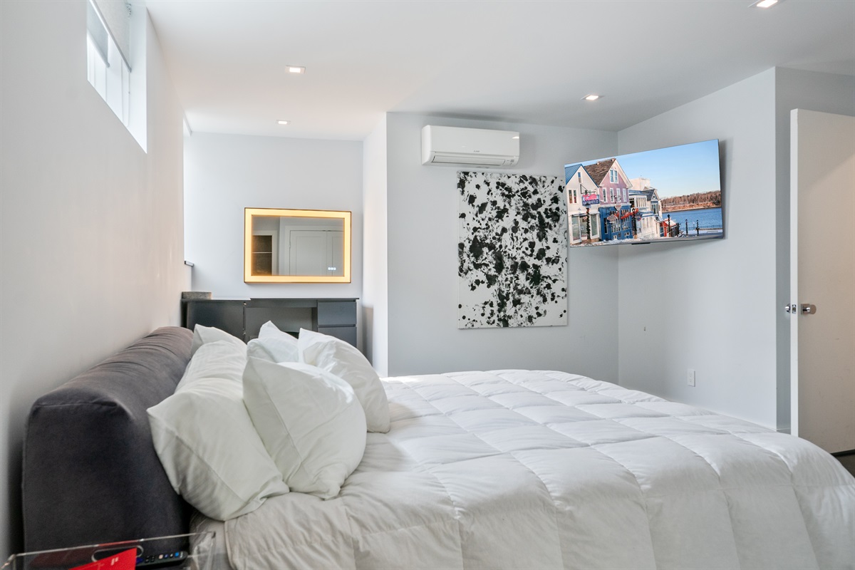 Primary Suite features a 55-inch Smart TV and original custom art. Experience total comfort from the King bed with dedicated air conditioning and integrated lighting, creating a sophisticated retreat in the center of Bar Harbor.