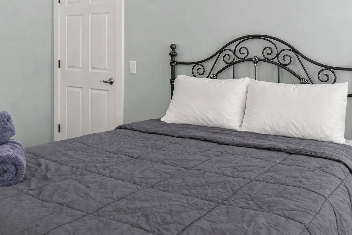 Detailed look at the queen bed and headboard, showcasing comfort and classic design touches.