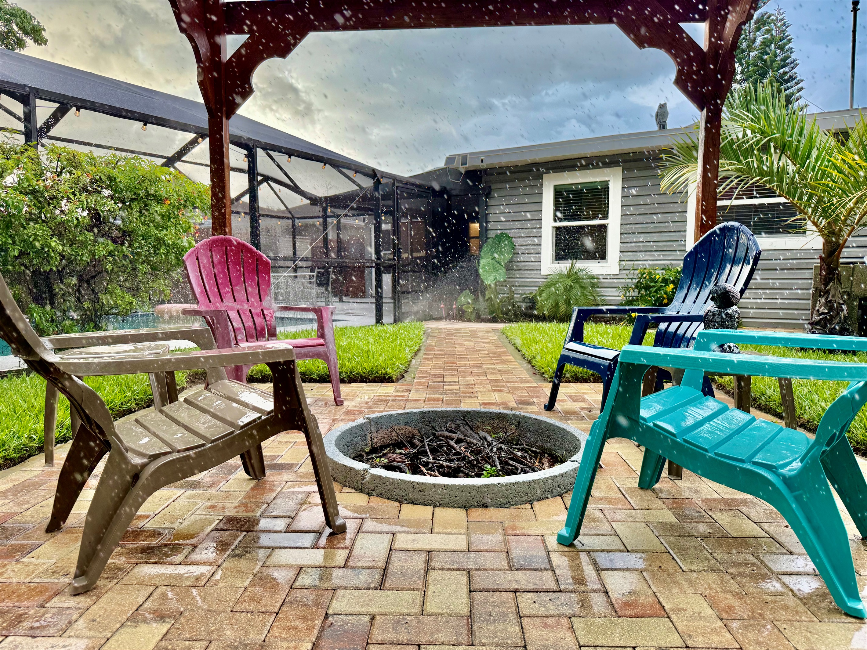 Pull up a colorful Adirondack chair, light the fire, and unwind beneath the open beams of this stunning backyard retreat.