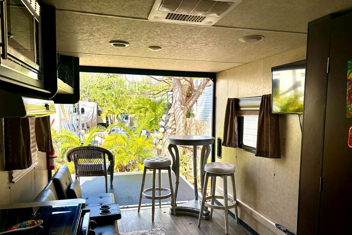 Living area with wall dropped down. TV, table, couch.