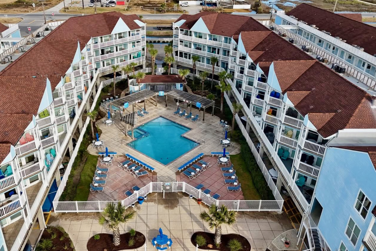 Bird’s-eye view of your beachfront resort—private balconies, heated pools, and seamless beach access on Galveston’s peaceful West End.