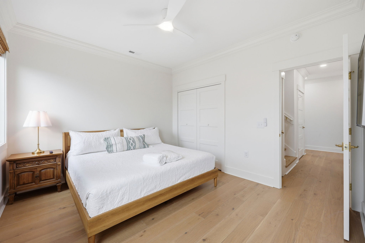 Second-floor king bedroom featuring coastal finishes and bright natural light