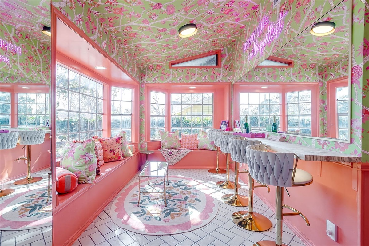 Where glam squads gather. Velvet bar seating for five, bench space for seven more, neon lights, bold wallpaper, and mirrors made for getting ready together.