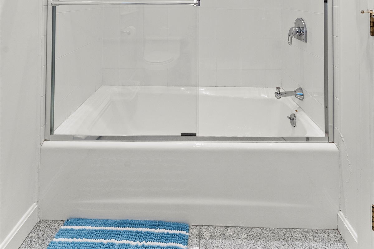 Main-level bathroom featuring a combination tub and shower.