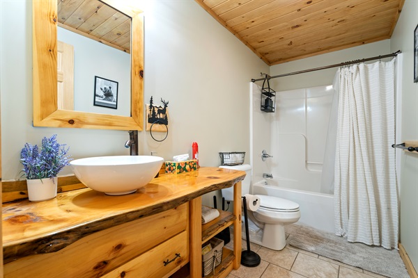 Another guest-ready bathroom featuring a full tub and all the essentials.