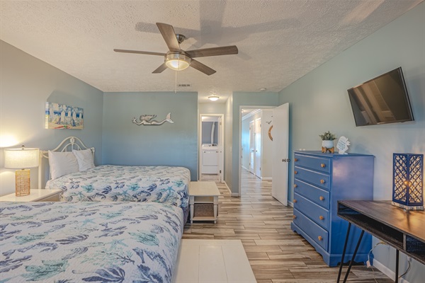 Guest bedroom with two beds, bathroom access, and smart TV