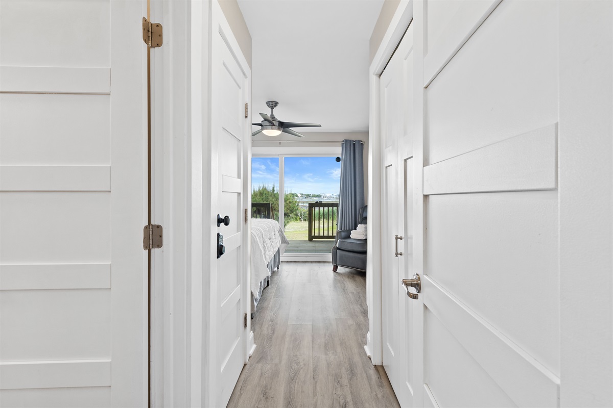 Entry hallway leading into the bright king bedroom with deck views