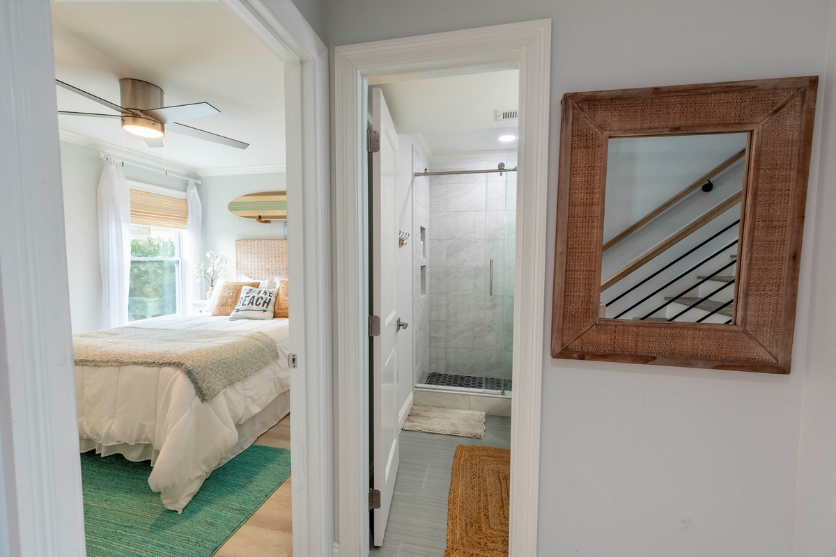 Relaxing retreat: Cozy bedroom and modern bathroom with beachy elegance.