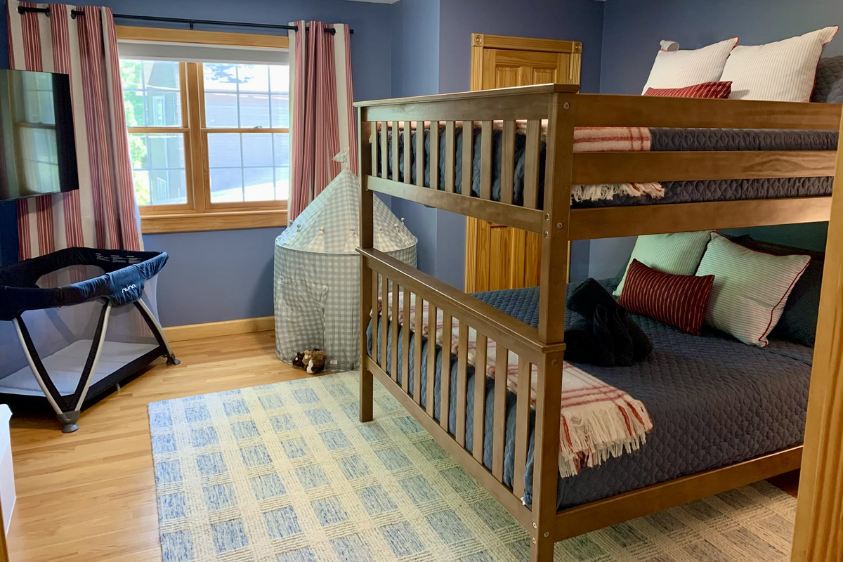 Our queen-over-queen bunk room combines spacious sleeping with family-friendly touches, including a smart TV, play tent, toy chest, Pack 'n Play.