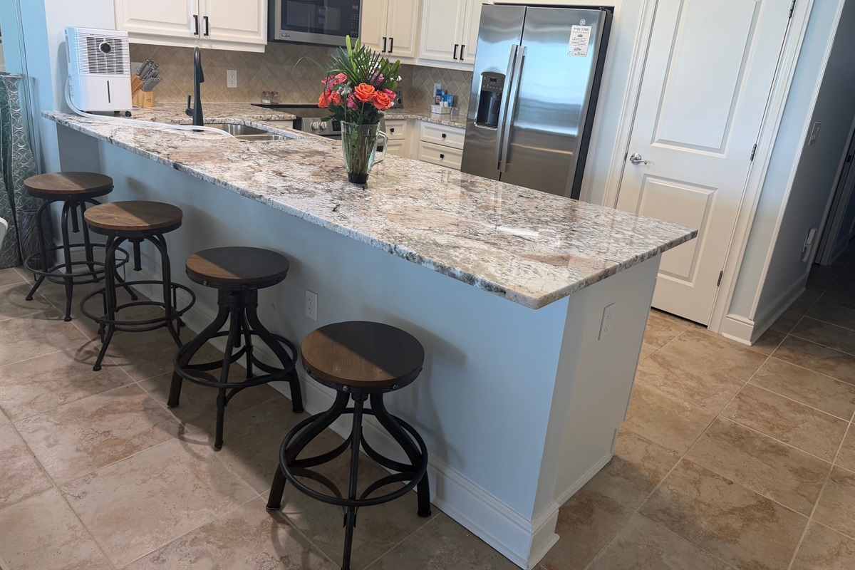 Spacious kitchen with granite countertops, stainless appliances, and bar seating—perfect for coffee mornings or family meals together.