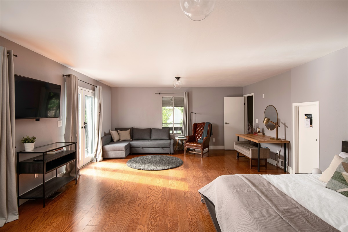 Oversized primary suite with lounge area, workspace, and deck access—perfect for relaxing, working, or unwinding in comfort.