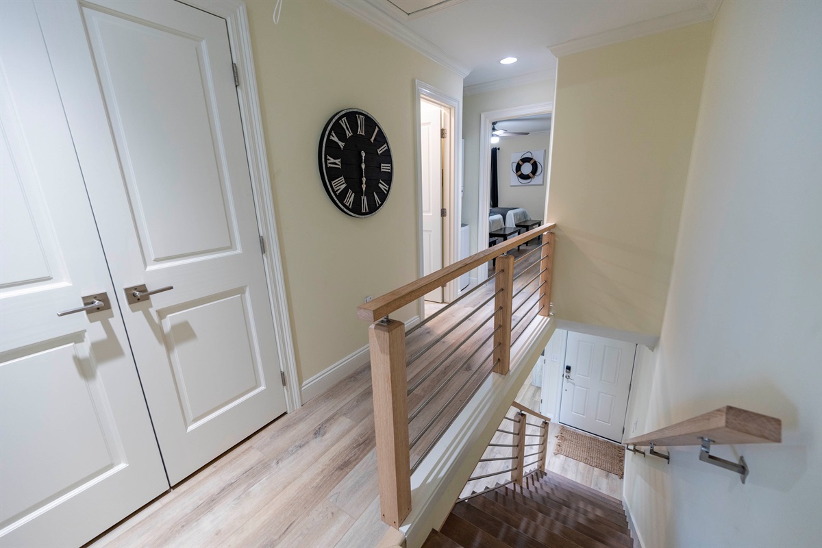 Bright and welcoming hallway with modern railings and cozy coastal vibes.
